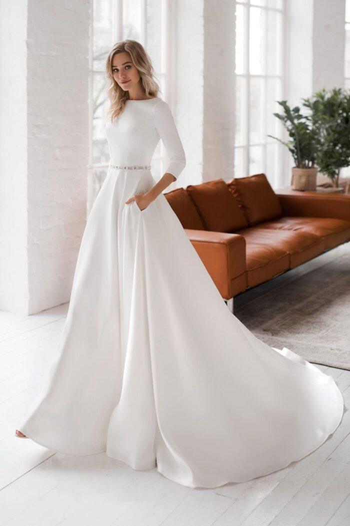 Bruk - Наталья Романова Bruk 1 Наталья Романова Сдержанный минимализм и роскошь - атласное свадебное платье А-силуэта от российского дизайнера. Bruk — это роскошь и стильность образа, дорогой блеск и фактура ткани, идеальный и скульптурный крой платья. Фактуру атласа идеально подчеркивает тонкий пояс из камней сваровски и рукава 3/4.