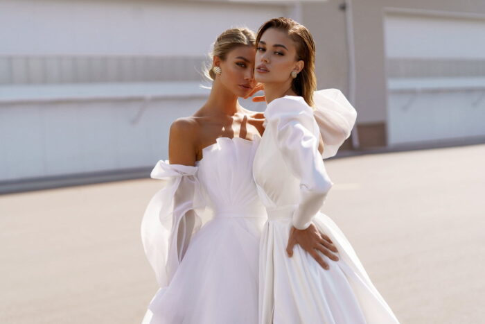 Lisbeth 2 Наталья Романова Свадебное платье с разрезом на юбке, с рукавами «жиго» и дизайнерским вырезом на спинке. Минималистичность кроя подчеркивает форму и элегантность платья.  Талия акцентирована широким поясом с прямоугольной пряжкой.