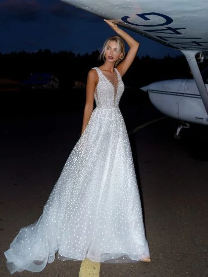 Келли 1 Наталья Романова Сделайте свой особый день ярче с нашим изысканным свадебным платьем А-силуэта. Это платье с привлекательным V-образным вырезом спереди, по бокам и открытой спиной позволит вам выглядеть и чувствовать себя принцессой. Изготовленный из роскошного тюля и сверкающих блесток, он станет идеальным выбором!