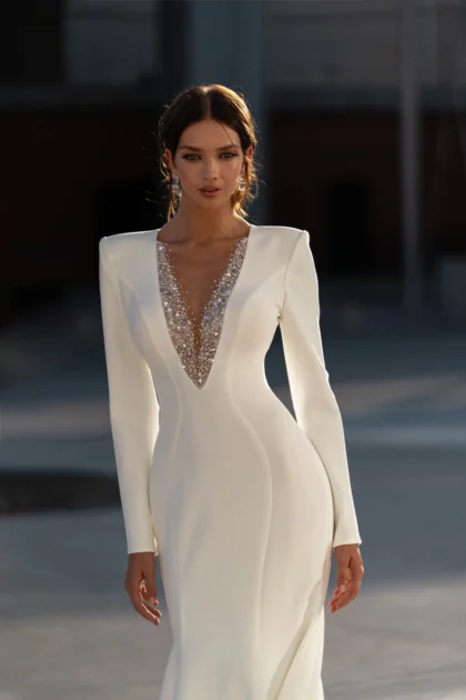 Констанция - Сонеста Констанция 1 Сонеста <p style="text-align: justify;">Это потрясающее свадебное платье, созданное для нежных и смелых романтических душ. Облегающий силуэт этого платья изготовлен из легкого крепа, который сделает ваш образ стильным и современным. Длинные рукава придают ему элегантность и утонченность, позволяя вам выглядеть восхитительно в любое время года. Сердце этого прекрасного платья - великолепный V-образный вырез, расшитый драгоценными кристаллами. Этот деталь придает платью особую изысканность и подчеркивает вашу неповторимую красоту. Для вашего удобства, спинка этого платья закрывается молнией, обеспечивая идеальную посадку и комфорт в течение всего дня. Основным материалом этого великолепного платья является креп – ткань с превосходной структурой и текстурой. А блеск кристаллов придаст вашему образу роскоши и индивидуальности. Это платье - идеальное сочетание прогрессивного стиля и романтизма. Оно подчеркнет вашу индивидуальность и придаст вашему свадебному образу неповторимый шарм и блеск.</p>
<iframe src="https://www.youtube.com/embed/opXdUpQ2vzo" width="auto" height="600" frameborder="0" allowfullscreen="allowfullscreen"></iframe>