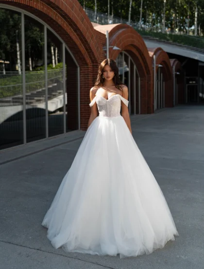 Лери 1 Сонеста <p style="text-align: justify;">В этом свадебном наряде, каждая линия и каждая деталь искрятся нежной романтикой и элегантностью. Свадебное платье в форме А-силуэта с грациозно спущенными бретелями призвано воплотить идеал дерзкой романтики для невесты, которая хочет выделяться своим неповторимым обаянием. Юбка из фатина легко пленяет сердца, сверкая и играя на свету. Она придает платью легкость и воздушность, словно нежный танец движется с каждым шагом невесты. Эта фатиновая юбка словно облако, которое ласкает и уносит далеко-далеко в легком и романтичном облаке счастья. Корсет этого великолепного наряда украшен драгоценными стежками бисера, добавляющими нотку необыкновенного блеска. Каждая маленькая бусинка словно запечатлевает искру любви, которая светится изнутри и придает платью особую магию. Он подчеркивает женственные очертания и делает силуэт стройным и изящным. Основными материалами этого изумительного наряда являются фатин и бисер, которые воплощают в себе нежность, элегантность и романтичность. Это платье подарит невесте ощущение принцессы, которая живет в мечтательном мире искрящейся любви и эмоций.</p>
<iframe src="https://www.youtube.com/embed/DY00iJin_g4" width="auto" height="600" frameborder="0" allowfullscreen="allowfullscreen"></iframe>