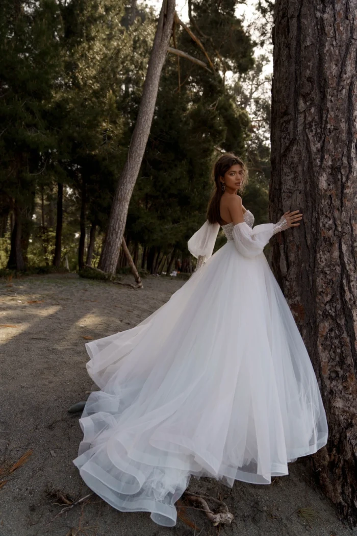 Маринн 1 Наталья Романова Выглядите потрясающе в этот особенный день в этом красивом свадебном платье! Роскошный бальный силуэт, отстегивающийся объемный рукав и спинка на внутреннем корсете со шнуровкой не оставят вас равнодушными. Это платье с роскошным тюлем и бисером идеально подходит для волшебного момента, когда можно сказать «да». 