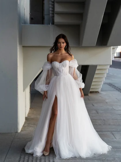 Николетта - Сонеста Николетта 1 Сонеста <p style="text-align: justify;">В пленительном облаке фатина искусно вышитого лифа, это свадебное платье А-силуэта вобрало в себя элегантность и современный романтизм. Его разрез в юбке придает образу невесты изысканную изящность и провокационную нотку. Лиф этого завораживающего творения окутывает тело в форме сердечка, пленяя внимание и обрамляя декольте нежной россыпью вышитых деталей. Можно выбрать стиль с бретелями, которые спускаются нежно и провокационно по плечам, или с объемными рукавами-баффами, добавляющими оригинальности и элегантности образу. Главной фантазией платья является его основной материал - фатин. Он создает вуальную легкость и непринужденность, позволяя невесте свободно двигаться и чувствовать себя легкой, как перышко. Это платье - объятие современного романтизма и элегантности, идеально подходящее для невесты, мечтающей о воплощении своего любовного сказочного идеала.</p>
<iframe src="https://www.youtube.com/embed/F7HGvGtQNrU" width="auto" height="600" frameborder="0" allowfullscreen="allowfullscreen"></iframe>