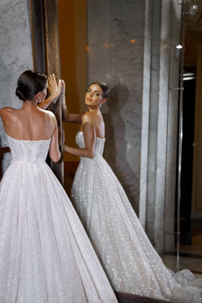 Биарриц - Патрисия Кутюр Биарриц 4 Патрисия Кутюр <p style="text-align: justify;">Волшебное свадебное платье, созданное для тех, кто стремится погрузиться в волнующий мир романтизма и элегантности. Это платье величественного А-силуэта украшает сразу несколько выразительных деталей, которые будут захватывать взоры гостей. Изящный вырез в форме сердца придаёт этому наряду особую спокойную романтическую атмосферу, олицетворяющую истинную любовь. Оно воплощает гармонию страсти и нежности, идеально подчеркивая красоту и изящество невесты. Элегантная спинка с застежкой на молнии добавляет изюминку этому платью. Она создаёт идеальную поддержку и подчёркивает изящество фигуры, одновременно демонстрируя сдержанность и таинственность. Основные материалы, использованные в этом шедевре, - кружево, фатин и глиттер. Нежные кружевные узоры придают элегантность и изящество, фатин добавляет воздушность и легкость, а блестки придают наряду призрачное сияние, создавая ощущение магии и сказки. Это платье - истинная мечта, воплощение современного романтизма, которое будет подарком невесте, чтобы она чувствовала себя волшебной на своём самом важном дне.</p>