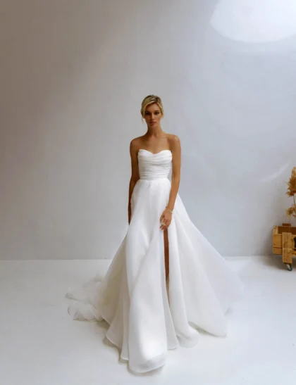 Лавли - Наталья Романова Лавли 1 Наталья Романова Свадебное платье А-силуэта с открытым верхом и разрезом на юбке. Корсет на молнии.