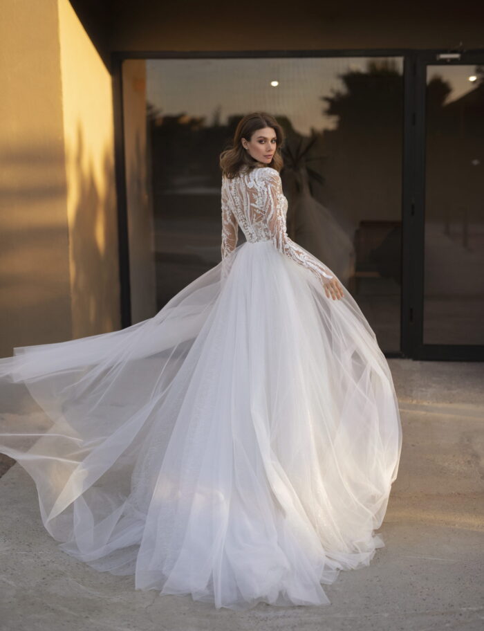 Кармелия 1 Наталья Романова <p style="text-align: justify;">Свадебное платье символизирующее нежность и романтику. Это свадебное платье А-силуэта с длинными рукавами и воротником-стоечкой – истинное воплощение элегантности и изящества. Верх платья полностью выполнен из прекрасного кружева, которое придает ему изысканный и романтический шарм. Каждый узор и цветок кружева с любовью продуман, чтобы подчеркнуть вашу естественную красоту и роскошь. Особенностью этого наряда является спинка на внутреннем корсете со шнуровкой и пуговичками, которые добавляют дополнительно дозу женственности и роскоши. Нежный фатин используется в качестве основного материала, он создает эффект легкости и воздушности, словно вы парите в облаках на своем особенном дне. В этом платье вы будете выглядеть не только красиво, но и поистине принцессой в своей сказке о любви. Оно подарит вам уверенность и элегантность, притягивая все взгляды на вас. С этим платьем ваша свадебная церемония станет запоминающейся и волшебной.</p>
<iframe src="https://www.youtube.com/embed/NLVrAmbC848" width="auto" height="600" frameborder="0" allowfullscreen="allowfullscreen"></iframe>