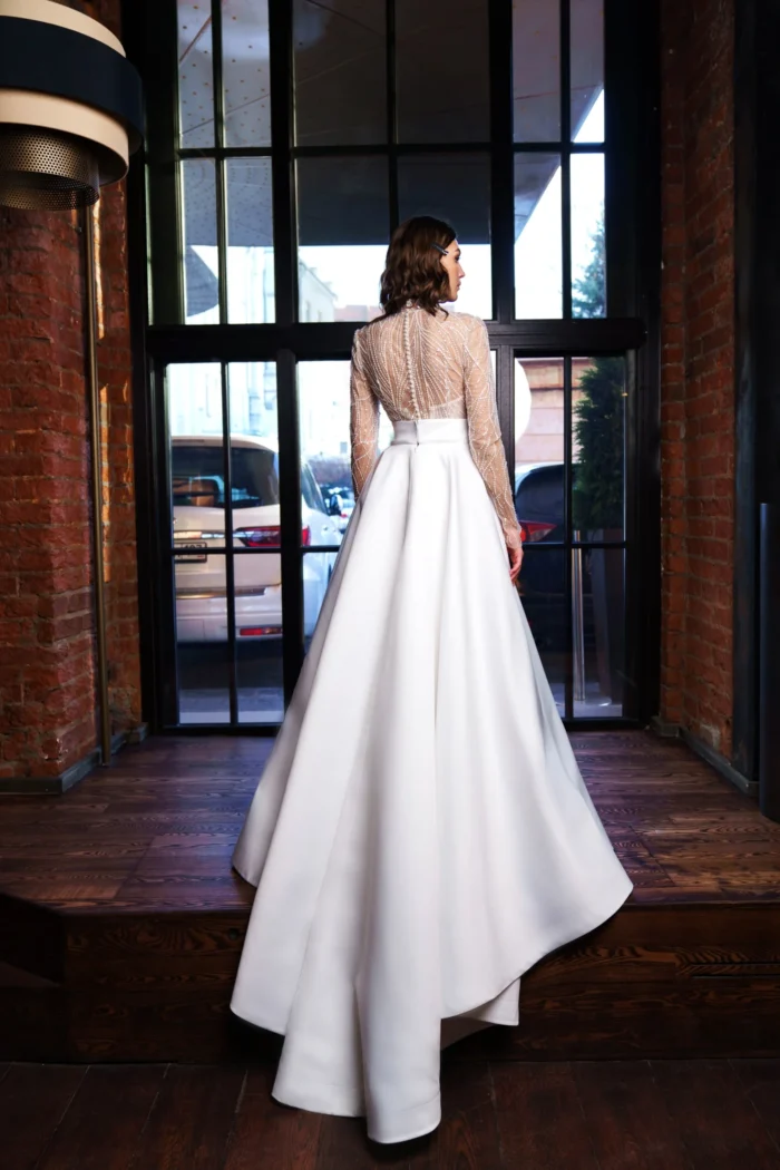 Дана 1 Сониа Солей <p style="text-align: justify;">Свадебное платье А-силуэта с длинными рукавами и спинкой на пуговичках - идеальный выбор для невесты, желающей создать элегантный и утонченный образ в свой особенный день. Оно выполнено из высококачественного атласа, который придает платью роскошный и блестящий вид. Легкий глиттер добавляет изысканности и придаёт платью неповторимое сияние. А-силуэт позволяет подчеркнуть женственные формы и создает изящный силуэт. Длинные рукава добавляют нотку загадочности и романтики, а спинка, закрытая пуговицами, дополняет образ наружной простотой и внутренней изысканностью. Это платье идеально подходит как для классических, так и для современных свадебных церемоний. Оно будет покорять сердца с первого взгляда и оставит незабываемые впечатления у всех присутствующих. Выбирая это свадебное платье, невеста получает комфорт, элегантность и шик в одном образе.</p>
<iframe src="https://www.youtube.com/embed/NO0lHOX3vxU" width="auto" height="600" frameborder="0" allowfullscreen="allowfullscreen"></iframe>