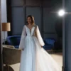 Ева 1 Сониа Солей <p style="text-align: justify;">Свадебное платье Ева А-силуэта - это идеальный выбор для невест, которые хотят выглядеть элегантно и впечатляюще в свой важный день. Это платье имеет V-образный вырез, который подчеркивает красоту шеи и груди, придавая образу нежности и женственности. Но самым впечатляющим элементом этого платья являются объемные крылья на плечиках, которые создают эффектное и роскошное ощущение. Они придают платью небесный и легкий вид, как будто невеста летит под венец. Спинка платья застегивается на молнии, что обеспечивает удобное и легкое надевание. Это позволяет невесте чувствовать комфорт на протяжении всего свадебного мероприятия. Основной материал, используемый в этом платье, - это фатин. Фатин - легкая, но одновременно элегантная ткань, которая создает воздушное и романтичное ощущение. В сочетании с глиттером, этот материал придает платью блеск и сияние, подчеркивая изысканность и роскошь внешнего вида. Свадебное платье Ева А-силуэта с V-образным вырезом и объемными крыльями на плечах является уникальным и неповторимым выбором для невесты, которая хочет быть обрамленной грацией и роскошью в свой великий день.</p>
<iframe src="https://www.youtube.com/embed/_WmakzHHiM0" width="auto" height="600" frameborder="0" allowfullscreen="allowfullscreen"></iframe>