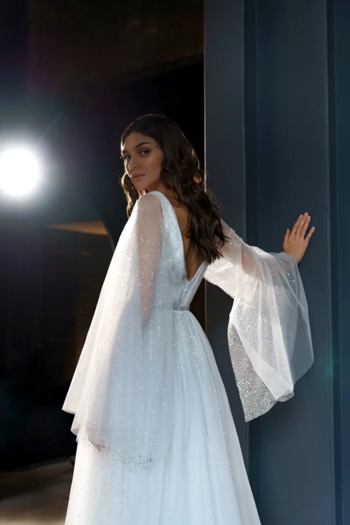 Ева 2 Сониа Солей <p style="text-align: justify;">Свадебное платье Ева А-силуэта - это идеальный выбор для невест, которые хотят выглядеть элегантно и впечатляюще в свой важный день. Это платье имеет V-образный вырез, который подчеркивает красоту шеи и груди, придавая образу нежности и женственности. Но самым впечатляющим элементом этого платья являются объемные крылья на плечиках, которые создают эффектное и роскошное ощущение. Они придают платью небесный и легкий вид, как будто невеста летит под венец. Спинка платья застегивается на молнии, что обеспечивает удобное и легкое надевание. Это позволяет невесте чувствовать комфорт на протяжении всего свадебного мероприятия. Основной материал, используемый в этом платье, - это фатин. Фатин - легкая, но одновременно элегантная ткань, которая создает воздушное и романтичное ощущение. В сочетании с глиттером, этот материал придает платью блеск и сияние, подчеркивая изысканность и роскошь внешнего вида. Свадебное платье Ева А-силуэта с V-образным вырезом и объемными крыльями на плечах является уникальным и неповторимым выбором для невесты, которая хочет быть обрамленной грацией и роскошью в свой великий день.</p>
<iframe src="https://www.youtube.com/embed/_WmakzHHiM0" width="auto" height="600" frameborder="0" allowfullscreen="allowfullscreen"></iframe>