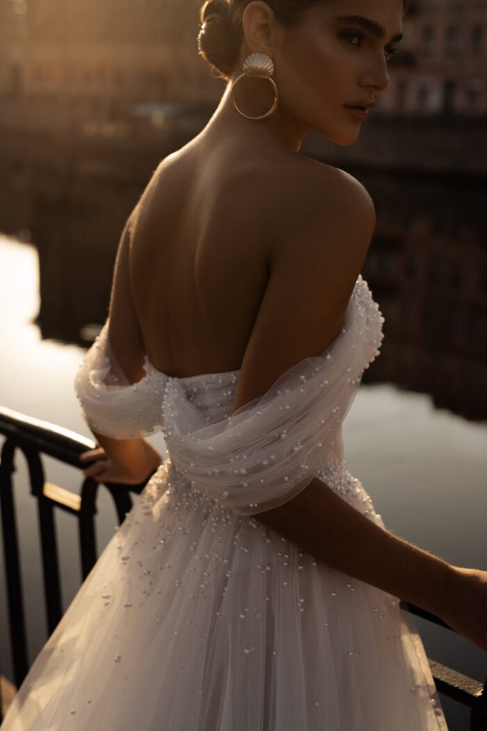 Гелла 4 Патрисия Кутюр <p style="text-align: justify;">Изысканное свадебное платье, которое сочетает в себе элегантность и романтичность. Это великолепное платье А-силуэта создано для того, чтобы подчеркнуть вашу женственность и придать вам неповторимый образ в ваш особенный день. Спущенные бретели придают платью нежности и изысканности, а расшитый корсет добавляет нотки роскоши и великолепия. Основной материал этого шедевра - фатин, пропускающий свет и создающий эффект легкости и воздушности, словно загадочная пелена, окружающая вас на фоне волшебного дня. Бисерные жемчужины, расшитые на корсете, добавляют впечатления блеска и элегантности, словно звезды, которые сверкают на небосклоне. Это платье не только воплощает мастерское искусство и утонченные детали, оно также является символом любви и романтики. В нем каждая стежка становится главой истории вашей любви. Оно позволит вам ощутить себя настоящей принцессой, готовую вступить в мир волшебства и счастья. Пускай это свадебное платье станет инкарнацией вашей мечты и позволит вам ощутить себя самой красивой и безупречной. Оно будет не только вашим нарядом, но и памятным символом вашей вечной любви.</p>
<iframe src="https://www.youtube.com/embed/jkeR52cmjsM" width="auto" height="600" frameborder="0" allowfullscreen="allowfullscreen"></iframe>