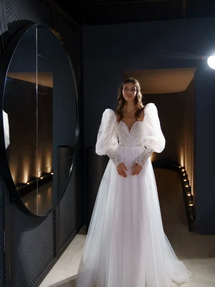 Ливия - Сониа Солей Ливия 1 Сониа Солей <p style="text-align: justify;">Свадебное платье Ливия - это изящное и романтичное платье в стиле А-силуэта, созданное для создания неповторимого образа невесты. Оно имеет объемные рукава и спинку на внутреннем корсете со шнуровкой и пуговичками, что придает ему особую изысканность. Основной материал этого платья - фатин, который придает ему легкость и воздушность. Кружево, используемое в дизайне платья, добавляет ему элегантности и изысканности, подчеркивая женственные черты невесты. Органза в платье придает ему объем и дополнительную игривость. Свадебное платье Ливия прекрасно подойдет для невесты, которая хочет выглядеть изысканно и неповторимо в свой особенный день. Его дизайн и материалы создадут воздушный и элегантный образ, который будет запоминаться на долгое время.</p>
<iframe src="https://www.youtube.com/embed/2vvifKydu4I" width="auto" height="600" frameborder="0" allowfullscreen="allowfullscreen"></iframe>