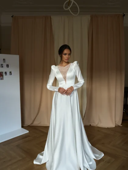 Рут - Сониа Солей Рут 1 Сониа Солей Роскошное свадебное платье А-силуэта, выполненное из высококачественного атласа. Отличительной особенностью данного наряда является его изысканный V-образный вырез, декорированный сверкающими пайетками, которые придают платью неповторимый шарм. Длинные рукава создают дополнительную утонченность и элегантность образа. Сзади платье имеет удобную молнию, позволяющую невесте легко надеть и снять наряд без посторонней помощи. Это идеальное платье для тех, кто хочет выглядеть безупречно в свой особенный день.
<iframe src="https://www.youtube.com/embed/CGbjjDcQplE" width="auto" height="600" frameborder="0" allowfullscreen="allowfullscreen"></iframe>