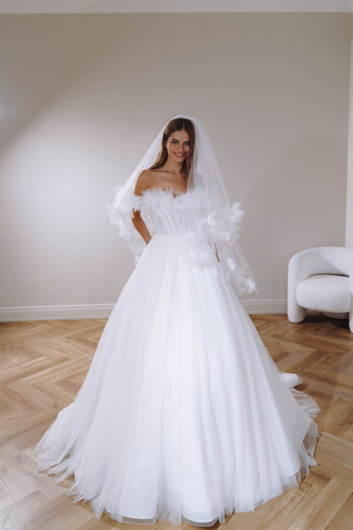 Софи - Патрисия Кутюр Софи 7 Патрисия Кутюр <p style="text-align: justify;">Это свадебное платье бального силуэта в романтическом стиле – идеальный выбор для тех, кто мечтает быть принцессой на своей свадьбе. Спущенные бретели придают платью нежности, а спинка, украшенная внутренним корсетом со шнуровкой, выглядит элегантно и роскошно. Но что делает это платье по-настоящему восхитительным, так это его уникальное декорирование. На фоне плиссированной органзы, которая создает эффект деликатной текстуры и легкости, располагаются трехмерные цветы. Эти цветы из плиссированной органзы создают впечатление лепестков, легко касающихся кожи. Они добавляют платью изящности и романтичности. Основной материал - плиссированная органза, выбранный не только благодаря своей легкости и нежности, но и из-за своей способности создавать волшебные оттенки и отражения света. Фатин же используется для добавления объема и создания игривых, плавных слоев. Это свадебное платье в каждом шовчике наполнено нежностью и прекрасными деталями, чтобы подчеркнуть вашу красоту и сказочность в этот важный день вашей жизни.</p>
<iframe src="https://www.youtube.com/embed/cZUla0scSzg" width="auto" height="600" frameborder="0" allowfullscreen="allowfullscreen"></iframe>