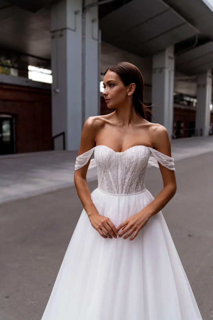 Сибилл - Сонеста Сибилл 3 Сонеста <p style="text-align: justify;">Романтическое свадебное платье, которое сияет светом любви и мечты. Это прекрасное свадебное платье А-силуэта, созданное с использованием самых изысканных материалов, чтобы вы сияли на своем особенном дне. Изящный фатин, подобно нежному облачку нежности, обрамляет вашу фигуру, придавая ей легкость и воздушность. А блестящая подкладка, легко просвечивая сквозь фатин, словно придаёт вашему образу загадочный и сказочный блеск. Корсет платья – настоящее произведение искусства. Он расшит бисером с нежными цветочными узорами, которые исторгаются в свете сияющих кристаллов и создают игру света и тени на вашем плече и линии декольте. Эти ослепительные детали подчеркивают вашу женственность и придают вашему облику особый шарм. Созданное с любовью и заботой, это платье излучает романтику и мечту. Оно захватывает душу своей изысканностью и притягивает взгляды всех присутствующих. В нем каждая ваша прогулка к алтарю будет напоминать танец на облаках, а каждый миг будет запечатлен в памяти, как самая романтическая глава вашей истории любви.</p>
<iframe src="https://www.youtube.com/embed/UIyJ7qy7jto" width="auto" height="600" frameborder="0" allowfullscreen="allowfullscreen"></iframe>