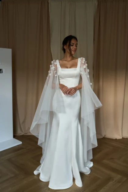 Долорес - Сониа Солей Долорес 1 Сониа Солей Это свадебное платье подчеркивает фигуру невесты благодаря облегающему силуэту и широким бретелям. Спинка платья застегивается на молнию, что обеспечивает удобство и комфорт. Платье выполнено из тонкого атласа, который придает ему элегантность и блеск. Для создания романтического образа можно добавить съемный кейп из фатина, украшенный 3D цветами. Кейп легко крепится к платью и создает эффект пышной юбки. Цвет платья - молочный, что подходит для светлых и темных типов кожи.
<iframe src="https://www.youtube.com/embed/VXE2VoEbQ0g" width="auto" height="600" frameborder="0" allowfullscreen="allowfullscreen"></iframe>