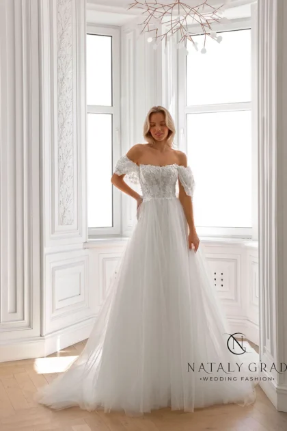 Маргарет 1 Nataly Grad <p style="text-align: justify;">Платье А-силуэта, создающего женственный и элегантный образ. Его основа выполнена из мягкого, воздушного фатина, придающего наряду роскошный и торжественный вид. Важной особенностью этого платья является кружевная отделка, которая добавляет ему винтажное очарование и утонченность. Кружево присутствует в различных элементах: по краям лифа, на юбке, создавая изящные узоры. Длина платья - в пол, что придает ему величественный и торжественный вид. Отсутствие рукавов и открытые плечи делают образ более легким и воздушным, подчеркивая хрупкость и женственность невесты. Особенностью конструкции является спущенная линия плеч, что создает еще более соблазнительный и романтичный силуэт.</p>