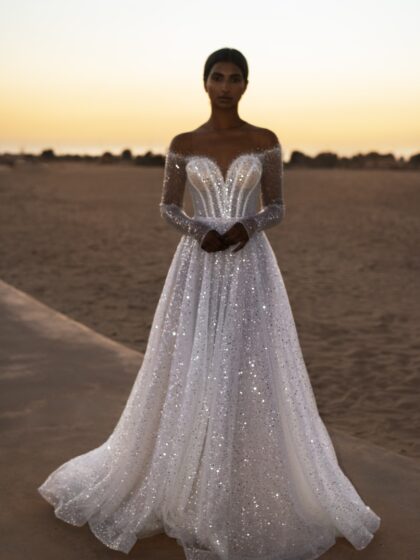 Амальфея - Наталья Романова Амальфея 1 Наталья Романова <p style="text-align: justify;">Свадебное платье А-силуэта с длинными рукавами — это изысканный выбор для невесты, желающей выглядеть элегантно и романтично. А-силуэт создает утонченный и гармоничный образ, подходящий для невест всех фигур. Это платье подчеркивает линию талии и скрывает возможные недостатки, даря уверенность и комфорт.
Основной материал — фатин — добавляет платью легкость и воздушность. Его текстура прекрасно драпируется, создавая нежные и романтичные линии. Длинные рукава из фатина придают наряду элегантность и утонченность, что особенно актуально для осенних и зимних свадеб.
Декор из бисера и пайеток является изюминкой этого платья, добавляя ему блеска и праздничного настроения. Бисер использован для создания изысканных узоров и деталей, которые притягивают взгляд, а пайетки обеспечивают эффектное сверкание при любом движении.
Такое свадебное платье идеально подходит для классической или романтической свадьбы.
Модель доступна в размере плюс сайз.</p>
<iframe id="video-iframe" src="https://www.youtube.com/embed/cn_kbdbwatA" width="auto" height="600" frameborder="0" allowfullscreen="allowfullscreen"></iframe>