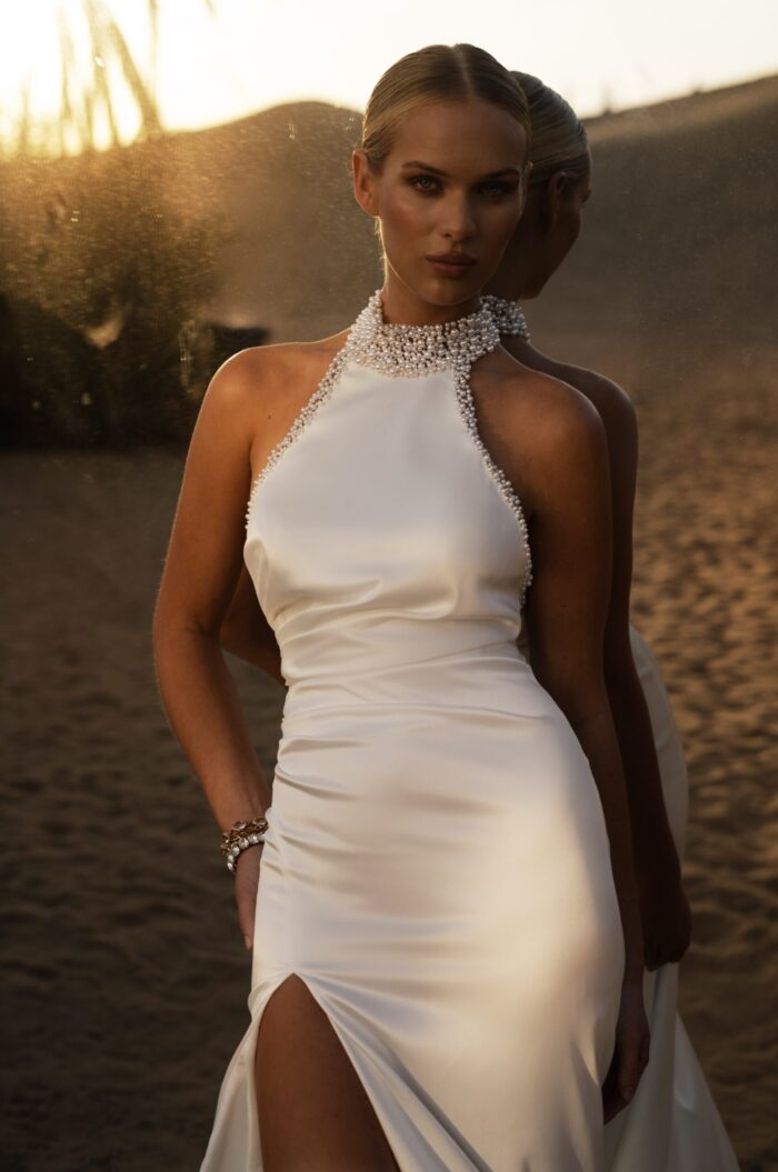 Эйлид 1 Наталья Романова <p style="text-align: justify;">Свадебное платье облегающего силуэта с американской проймой и открытой спиной — невероятно стильный и соблазнительный выбор для невесты.
Американская пройма подчеркивает плечи и придает образу выразительности, а открытая спина добавляет нотку игривости и женственности. Воротник и корсет, расшитые жемчужинами, придают наряду роскошный вид и демонстрируют внимание к деталям.
Основной материал — тонкий атлас — делает платье комфортным и приятным на ощупь, а также создает роскошное сияние, которое будет эффектно переливаться в свете. Это платье идеально подойдет для невест, желающих сочетать элегантность с модернистским стилем, создавая запоминающийся образ.
Модель доступна в размере плюс сайз.</p>
<iframe id="video-iframe" src="https://www.youtube.com/embed/bgxvYJbp2cE" width="auto" height="600" frameborder="0" allowfullscreen="allowfullscreen"></iframe>