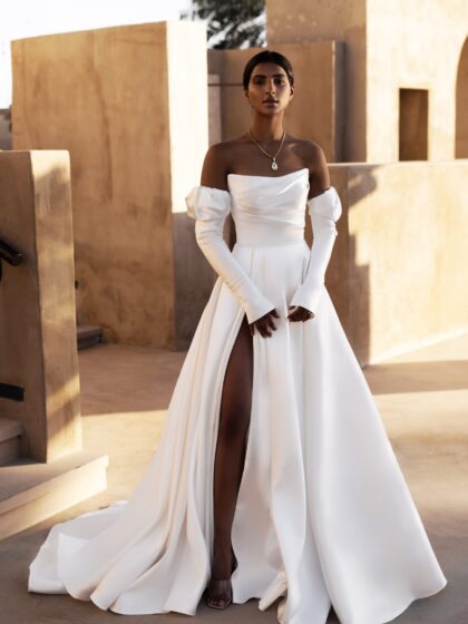 Манама 1 Наталья Романова <p style="text-align: justify;">Свадебное платье А-силуэта с разрезом в юбке — идеальный выбор для стильной невесты. Изготовлено из микадо, оно придает наряду роскошный вид и отлично держит форму.
Особенность платья в наличии съемных рукавов, что позволяет изменять образ в зависимости от настроения и стиля мероприятия. Разрез в юбке добавляет эффектности и удобства, подчеркнув элегантность ног и обеспечивая свободу движений.
Это платье подходит как для торжественной церемонии, так и для вечернего праздника, создавая превосходный и запоминающийся образ невесты.
Модель доступна в размере плюс сайз.</p>
<iframe id="video-iframe" src="https://www.youtube.com/embed/Mu2aUtdCkDM" width="auto" height="600" frameborder="0" allowfullscreen="allowfullscreen"></iframe>