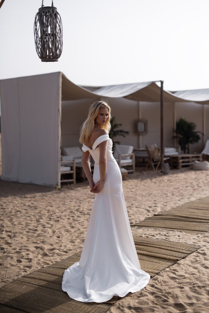 Нами - Наталья Романова Нами 1 Наталья Романова <p style="text-align: justify;">Свадебное платье облегающего силуэта с разрезом в юбке и съемными бретелями — это смелый и стильный выбор для невесты, желающей выделиться в день своей свадьбы.
Облегающий силуэт подчеркивает фигуру, создавая элегантный и утончённый образ, в то время как пышная юбка добавляет наряду объем и придаёт ему романтичную нотку. Разрез в юбке создает эффект движения и придаёт образу динамичность, что делает его ещё более привлекательным.
Съемные бретели позволяют легко менять стиль платья в зависимости от настроения и формата мероприятия. Это добавляет универсальности, позволяя невесте ощутить себя как в классическом, так и в более современном облачении.
Основной материал — микадо — известен своей прочностью и прелестным блеском, что делает платье не только стильным, но и комфортным. Это платье идеально подойдет как для торжественной церемонии, так и для вечернего праздника, создавая незабываемый образ для невесты.
Модель доступна в размере плюс сайз.</p>
<iframe id="video-iframe" src="https://www.youtube.com/embed/gHbQFSbu1Lc" width="auto" height="600" frameborder="0" allowfullscreen="allowfullscreen"></iframe>