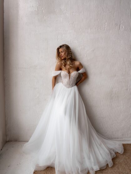 Нисса - Наталья Романова Нисса 1 Наталья Романова <p style="text-align: justify;">Свадебное платье А-силуэта со съемными бретелями и рукавами — это сочетание грации и изысканности. Корсет, расшитый бисером и пайетками, придает платью блеск и роскошь, акцентируя внимание на талии и верхней части наряда. Привлекательная игра света на поверхности корсета будет мерцать на каждом шаге, создавая эффектный визуальный акцент.
Съемные бретели и рукава добавляют разнообразия в образ. Невеста может легко изменить стиль, выбирая более классический или романтичный вариант в зависимости от настроения и формата мероприятия. Это также позволяет удобно адаптировать платье к различным условиям — например, сняв рукава для вечерней части праздника.
Основной материал — фатин с пайетками — создает легкость и воздушность, что делает наряд невероятно красиво струящимся и романтичным. Это платье идеально подойдет как для церемонии, так и для вечернего приема, создавая незабываемый образ невесты.
Модель доступна в размере плюс сайз.</p>
<iframe id="video-iframe" src="https://www.youtube.com/embed/tPaxS3gO4fc" width="auto" height="600" frameborder="0" allowfullscreen="allowfullscreen"></iframe>