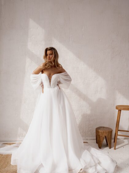 Сагата - Наталья Романова Сагата 4 Наталья Романова <p style="text-align: justify;">Свадебное платье А-силуэта со спущенными бретелями и прозрачными рукавами из фатина, расшитыми жемчужинами, — это нежный и романтичный выбор для невесты.
Спущенные бретели подчеркивают декольте и создают воздушный образ, а прозрачные рукава добавляют элегантности и утонченности. Жемчужные детали прекрасно акцентируют свет и придают платью изысканность.
Основной материал — органза — обеспечивает легкость и структуру наряда, придавая ему волшебный вид.
Модель доступна в размере плюс сайз.</p>
<iframe id="video-iframe" src="https://www.youtube.com/embed/X0AoPu6UpNI" width="auto" height="600" frameborder="0" allowfullscreen="allowfullscreen"></iframe>