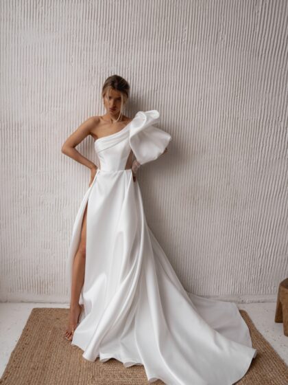 Савия - Наталья Романова Савия 1 Наталья Романова <p style="text-align: justify;">Свадебное платье А-силуэта с одним объемным рукавом, разрезом в юбке и телесными вставками на талии — это стильный и смелый выбор для невесты, желающей выделиться.
Объемный рукав придает драматичность, а разрез в юбке добавляет игривости и облегчает движение. Телесные вставки на талии создают эффект струящегося силуэта, подчеркивая женственность.
Изготовленное из микадо, платье обладает структурой и блеском, что делает его идеальным выбором для свадебного праздника. Это наряд для современных невест, стремящихся к уникальности и элегантности в своем образе.
Модель доступна в размере плюс сайз.</p>
<iframe id="video-iframe" src="https://www.youtube.com/embed/hehH5yVQ5KM" width="auto" height="600" frameborder="0" allowfullscreen="allowfullscreen"></iframe>