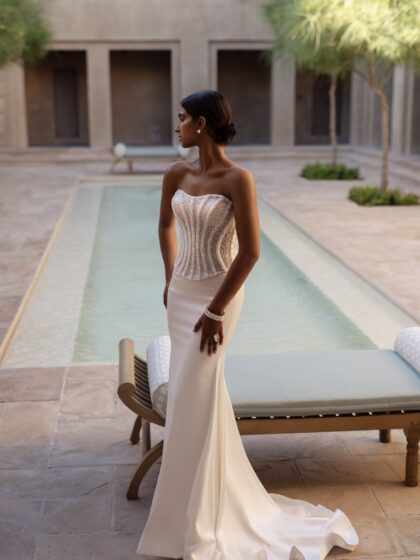 Ширин - Наталья Романова Ширин 1 Наталья Романова <p style="text-align: justify;">Свадебное платье из блестящего корсета и юбки облегающего силуэта — это смелый и эффектный выбор для невесты, желающей произвести впечатление.
Блестящий корсет подчеркивает фигуру и создает выразительный лифтинг-эффект, а юбка облегающего силуэта плавно облегает бедра, акцентируя достоинства фигуры. Основной материал — тонкий атлас с добавлением глиттера — придает платью роскошный блеск, который будет красиво переливаться в свете.
Такое платье идеально подходит для торжественной обстановки, позволяя невесте чувствовать себя как настоящая звезда на своем свадебном празднике.
Модель доступна в размере плюс сайз.</p>
<iframe id="video-iframe" src="https://www.youtube.com/embed/b-8OG4Gtn0s" width="auto" height="600" frameborder="0" allowfullscreen="allowfullscreen"></iframe>