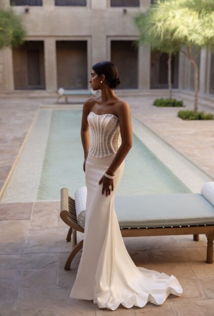 Ширин - Наталья Романова Ширин 1 Наталья Романова <p style="text-align: justify;">Свадебное платье из блестящего корсета и юбки облегающего силуэта — это смелый и эффектный выбор для невесты, желающей произвести впечатление.
Блестящий корсет подчеркивает фигуру и создает выразительный лифтинг-эффект, а юбка облегающего силуэта плавно облегает бедра, акцентируя достоинства фигуры. Основной материал — тонкий атлас с добавлением глиттера — придает платью роскошный блеск, который будет красиво переливаться в свете.
Такое платье идеально подходит для торжественной обстановки, позволяя невесте чувствовать себя как настоящая звезда на своем свадебном празднике.
Модель доступна в размере плюс сайз.</p>
<iframe id="video-iframe" src="https://www.youtube.com/embed/b-8OG4Gtn0s" width="auto" height="600" frameborder="0" allowfullscreen="allowfullscreen"></iframe>