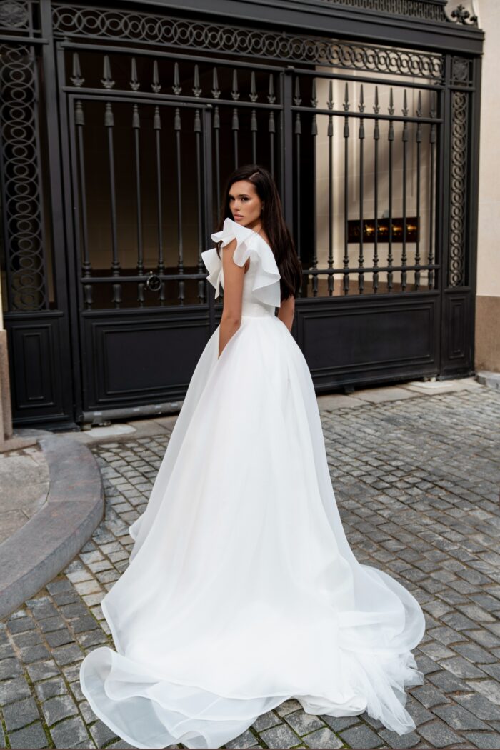 Вистерия 2 Сонеста <p style="text-align: justify;">Свадебное платье А-силуэта с одной бретелью и декором из роз ручной работы — это образец романтичности и современного стиля, который привлекает внимание и подчеркивает индивидуальность невесты. А-силуэт создает эффект легкости и воздушности, идеально подходя для создания изысканного образа.
Одно плечо открывает шею и плечо, добавляя нотку чувственности и элегантности, в то время как ручные розы служат великолепным акцентом, придающим платью уникальность и изящество. Декор из роз создает романтический настрой и отлично гармонирует с свадебной тематикой.
Основной материал — органза, известная своей легкостью и полупрозрачностью, создает эффект нежности и воздушности, а также добавляет объема юбке. Такое платье станет прекрасным выбором для летней или весенней свадьбы, подчеркивая красоту невесты. Оно станет идеальным фоном для счастья и любви, а детали ручной работы сделают образ по-настоящему уникальным.</p>
<iframe src="https://www.youtube.com/embed/ZoYVJEeM9FI" width="auto" height="600" frameborder="0" allowfullscreen="allowfullscreen"></iframe>