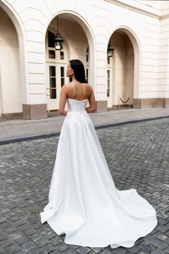 Вэйв - Сонеста Вэйв 1 Сонеста <p style="text-align: justify;">Свадебное платье А-силуэта с разрезом в юбке и съемным кружевным болеро — это стильный и элегантный выбор для невесты, которая хочет сочетать классические элементы с современными акцентами. А-силуэт обладает универсальностью и подходит для всех типов фигур, изящно подчеркивая талию и играя с пропорциями.
Разрез в юбке добавляет немного смелости и позволяет продемонстрировать ноги, что создает динамику в образе. Это решение идеально подходит для тех, кто хочет добавить нотку дерзости и игривости к своему наряду.
Съемное кружевное болеро — отличная деталь, позволяющая менять образ в течение дня. Оно придаст платью романтичности и нежности, а также обеспечит дополнительный уровень комфорта в прохладное время суток. Кружево контрастирует с гладкой текстурой микадо, добавляя интересный визуальный эффект.
Основной материал — микадо, известный своей структурностью и блеском, придает платью богатый и роскошный вид.</p>
<iframe src="https://www.youtube.com/embed/fL-FTYTJ70I" width="auto" height="600" frameborder="0" allowfullscreen="allowfullscreen"></iframe>