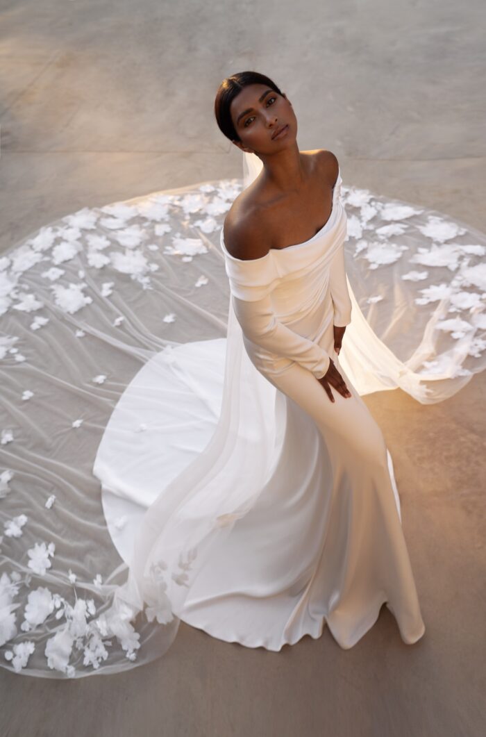 Яра - Наталья Романова Яра 5 Наталья Романова <p style="text-align: justify;">Свадебное платье облегающего силуэта с длинными рукавами — это классический и элегантный выбор для невесты, стремящейся к современному, но в то же время утонченному образу.
Длинные рукава добавляют платью нотку скромности и изысканности, делая его подходящим даже для более формальных свадебных церемоний. Спинка на молнии обеспечивает комфортную посадку и легкость в надевании, не нарушая при этом чистоты линий и стиля.
Основной материал — тонкий атлас — придает наряду мягкое сияние и позволяет юбке красиво ниспадать, создавая эффектный силуэт.
Модель доступна в размере плюс сайз.</p>
<iframe id="video-iframe" src="https://www.youtube.com/embed/cQ-nK5bfSzY" width="auto" height="600" frameborder="0" allowfullscreen="allowfullscreen"></iframe>