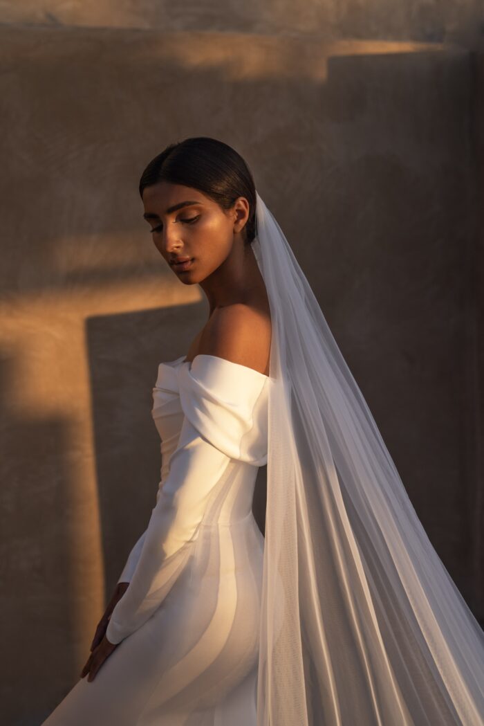 Яра - Наталья Романова Яра 2 Наталья Романова <p style="text-align: justify;">Свадебное платье облегающего силуэта с длинными рукавами — это классический и элегантный выбор для невесты, стремящейся к современному, но в то же время утонченному образу.
Длинные рукава добавляют платью нотку скромности и изысканности, делая его подходящим даже для более формальных свадебных церемоний. Спинка на молнии обеспечивает комфортную посадку и легкость в надевании, не нарушая при этом чистоты линий и стиля.
Основной материал — тонкий атлас — придает наряду мягкое сияние и позволяет юбке красиво ниспадать, создавая эффектный силуэт.
Модель доступна в размере плюс сайз.</p>
<iframe id="video-iframe" src="https://www.youtube.com/embed/cQ-nK5bfSzY" width="auto" height="600" frameborder="0" allowfullscreen="allowfullscreen"></iframe>