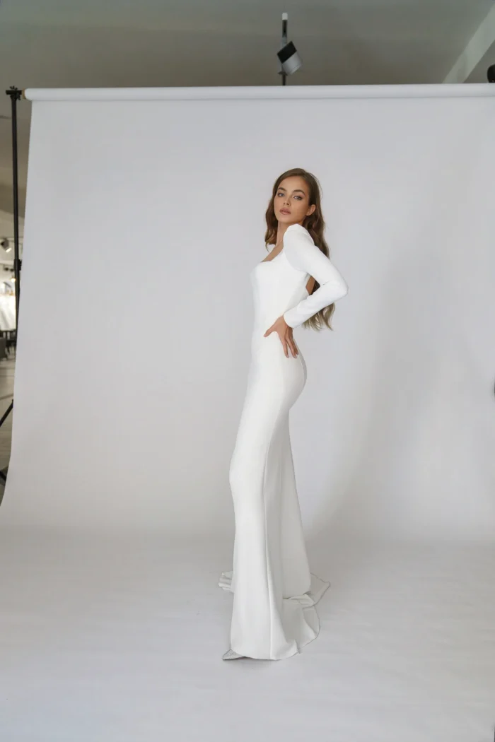 Орли - Martha (Марта) Орли 3 Martha (Марта) <p style="text-align: justify;">Свадебное платье облегающего силуэта с длинными рукавами и открытой спиной выполнено из крепа, что придаёт ему элегантный и стильный вид. Эта модель подчеркнёт все достоинства фигуры и добавит нотку смелости в образ невесты, сочетая классику и современность. Идеальный выбор для запоминающегося свадебного дня.</p>