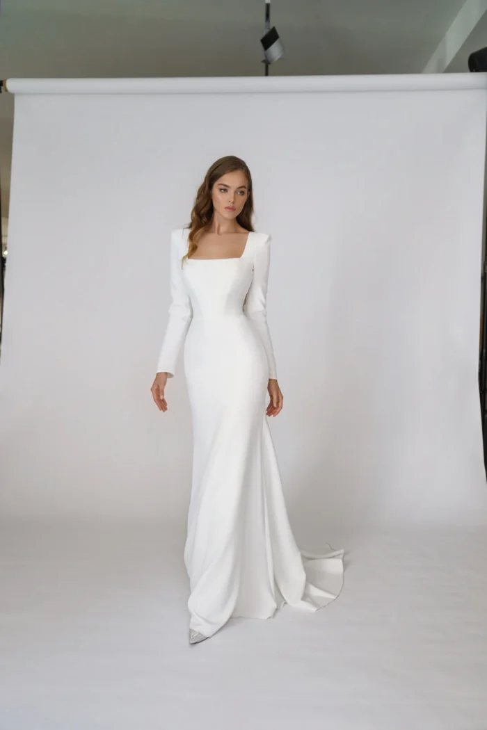 Орли - Martha (Марта) Орли 1 Martha (Марта) <p style="text-align: justify;">Свадебное платье облегающего силуэта с длинными рукавами и открытой спиной выполнено из крепа, что придаёт ему элегантный и стильный вид. Эта модель подчеркнёт все достоинства фигуры и добавит нотку смелости в образ невесты, сочетая классику и современность. Идеальный выбор для запоминающегося свадебного дня.</p>