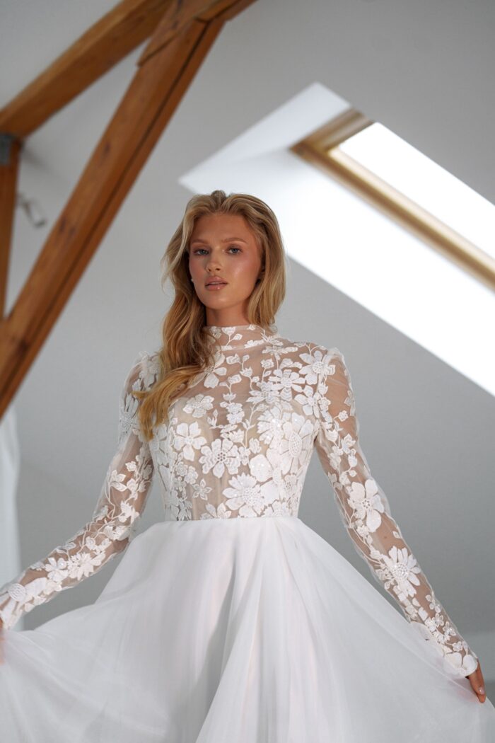 Лунар 5 Сониа Солей <p style="text-align: justify;">Свадебное платье А-силуэта с разрезом в юбке и закрытым корсетом — это воплощение романтической элегантности. Основной материал, органза и кружево, придают наряду легкость и воздушность, а изысканные детали делают его уникальным. Разрез в юбке добавляет нотку игривости и подчёркивает ноги, делая образ более динамичным. Закрытый корсет эффектно поддерживает и подчеркивает линию талии, создавая воздушный и одновременно строгий силуэт. </p>
<iframe src="https://www.youtube.com/embed/ND8I-hzzSLk" width="auto" height="600" frameborder="0" allowfullscreen="allowfullscreen"></iframe>