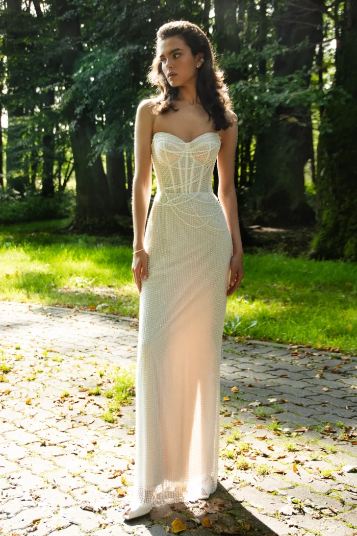 Дюпре 1 Наталья Романова <p style="text-align: justify;">Элегантное свадебное платье облегающего силуэта, украшенное изящными нитями жемчуга. Дополняется съёмной пышной юбкой из фатина и кружева, что позволяет легко менять образ — от утончённого минимализма до роскошного торжественного стиля.</p>
<iframe src="https://www.youtube.com/embed/0_GbZd4d9wU" width="auto" height="600" frameborder="0" allowfullscreen="allowfullscreen"></iframe>