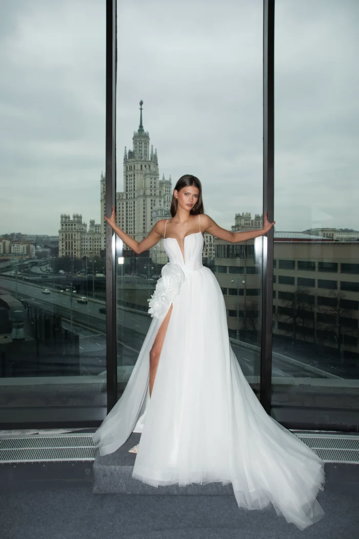 Эмрикс - Сонеста Эмрикс 1 Сонеста <p style="text-align: justify;">Свадебное платье А‑силуэта из воздушного фатина с изысканным V‑образным вырезом. Акцент на талии создан объёмным 3D‑цветком, который добавляет образу романтичности и утончённого шарма. Лёгкий силуэт подчёркивает нежность и торжественность наряда.</p>
<iframe src="https://www.youtube.com/embed/AjSr0hh1aXM" width="auto" height="600" frameborder="0" allowfullscreen="allowfullscreen"></iframe>