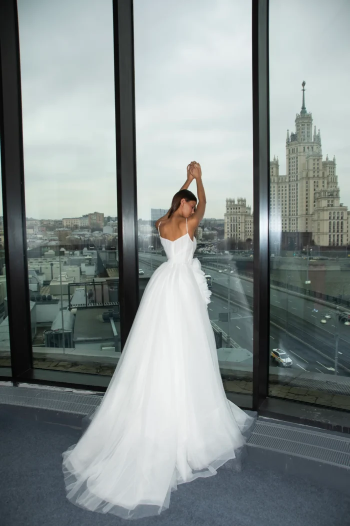 Эмрикс - Сонеста Эмрикс 2 Сонеста <p style="text-align: justify;">Свадебное платье А‑силуэта из воздушного фатина с изысканным V‑образным вырезом. Акцент на талии создан объёмным 3D‑цветком, который добавляет образу романтичности и утончённого шарма. Лёгкий силуэт подчёркивает нежность и торжественность наряда.</p>
<iframe src="https://www.youtube.com/embed/AjSr0hh1aXM" width="auto" height="600" frameborder="0" allowfullscreen="allowfullscreen"></iframe>