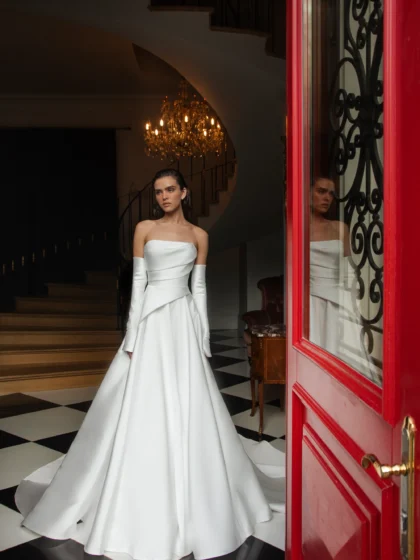 Лебрен 1 Наталья Романова <p style="text-align: justify;">Элегантное свадебное платье А‑силуэта из благородного микадо с асимметрией на линии талии. Образ дополняют съёмные перчатки, позволяющие легко менять стиль — от утончённой классики до современного акцента.</p>
<iframe src="https://www.youtube.com/embed/vQrdOl8Jdzo" width="auto" height="600" frameborder="0" allowfullscreen="allowfullscreen"></iframe>