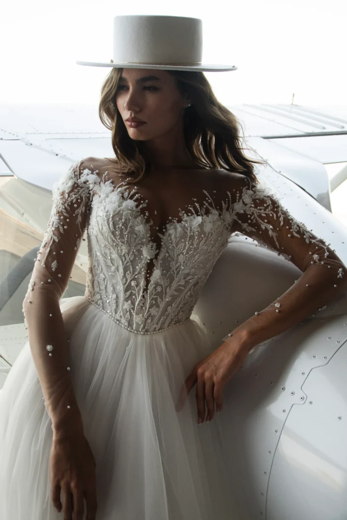 Шафран 1 Наталья Романова <p style="text-align: justify;">Изысканное свадебное платье А‑силуэта из воздушного фатина с элегантным V‑образным вырезом. Корсет расшит бисером и жемчугом, создавая утончённое мерцание и благородный акцент. Лёгкий силуэт подчёркивает романтичность образа, а жемчужные детали добавляют ему изящного сияния и торжественного шарма.</p>
<iframe src="https://www.youtube.com/embed/jmlX9tGZNPQ" width="auto" height="600" frameborder="0" allowfullscreen="allowfullscreen"></iframe>